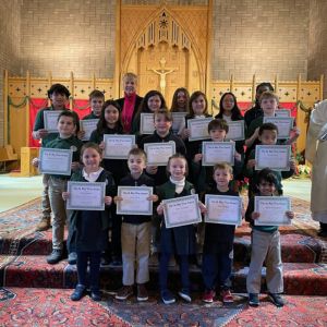 Group of happy students holding certificates in chapel