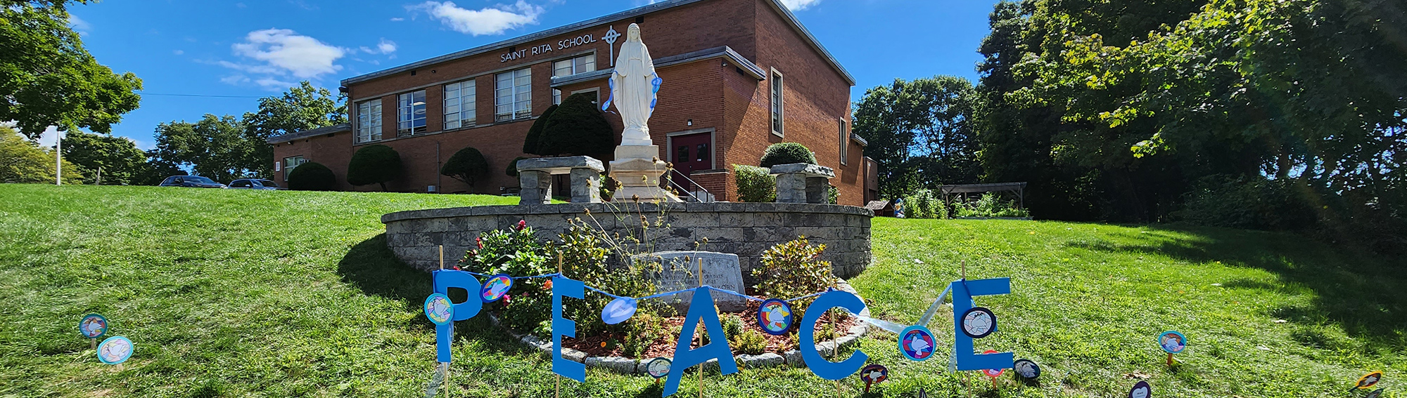 PEACE spelled out in the courtyard in front of Saint Rita School building