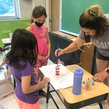 teacher and students with crafts