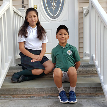 Two St. Rita siblings posing for a picture at home