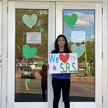 Middle school student holding up We love SRS sign